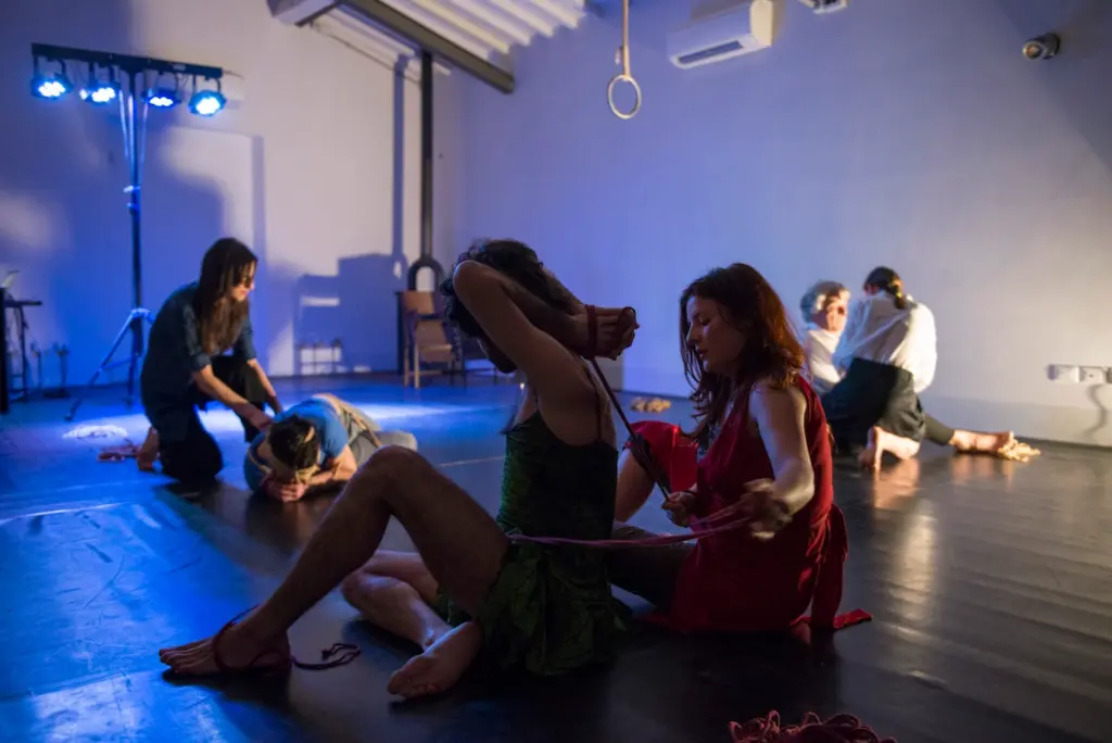 Shibari workshop with multiple couples practicing rope bondage techniques in a studio setting
