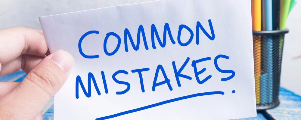 Common beginner mistakes sign written on a card held by hand.