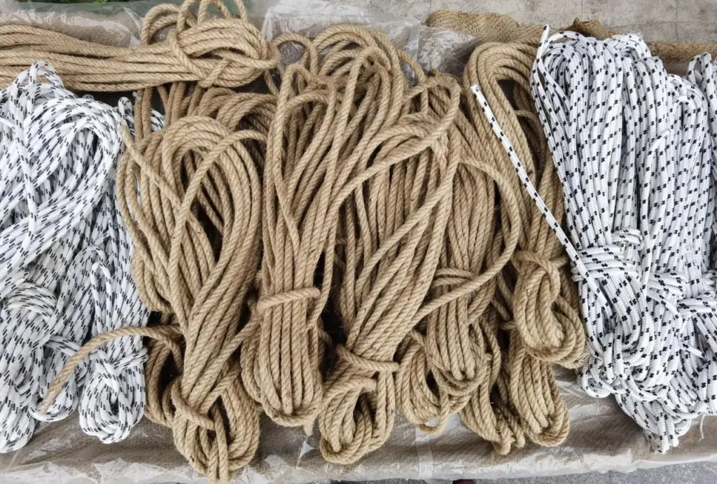 Different types of ropes used for shibari laid out showing natural fiber and synthetic rope bundles.